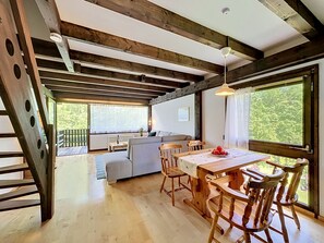 A wooden interior with a dining table, chairs, a sofa, and a staircase. - Ferienpark Vorauf by Interhome (Siegsdorf)