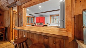 A wooden interior with a bar area, wooden walls, and a red cabinet.