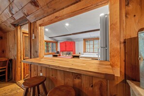 A wooden interior with a bar area, wooden walls, and a red cabinet.