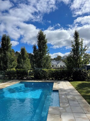 A rectangular swimming pool with clear blue water, surrounded by a paved patio. - Boutique farm-stay in The Southern Highlands with pool. Family + pet friendly. (Woodlands)