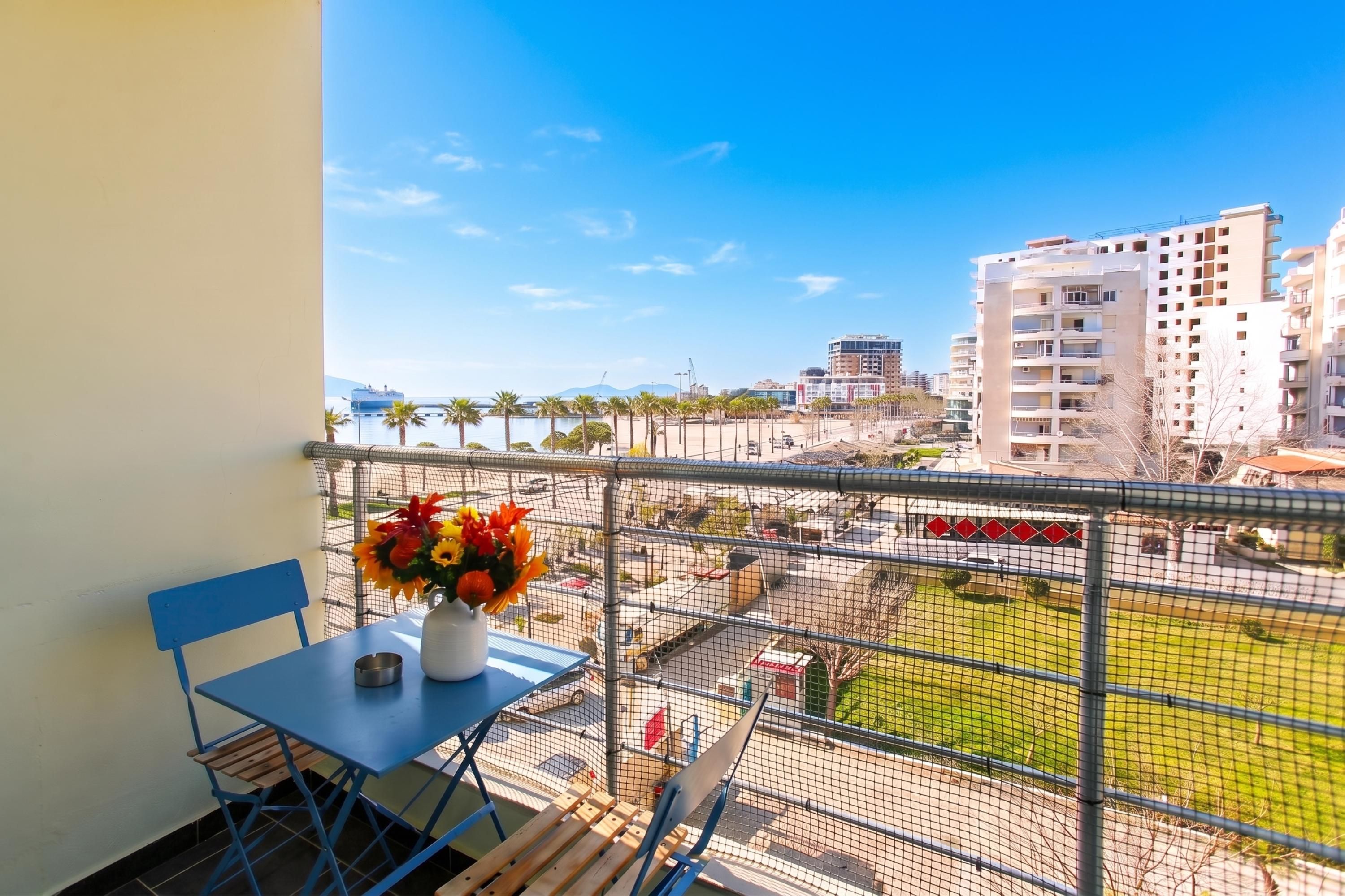 Ein Balkon mit Tisch, Stühlen und einem Blumenstrauß.