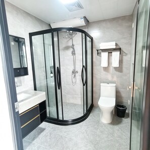 A modern bathroom with a glass-enclosed shower, a toilet, a sink with a mirror, and a towel rack. - Cloud House Of Leisurely (Zhangjiajie)