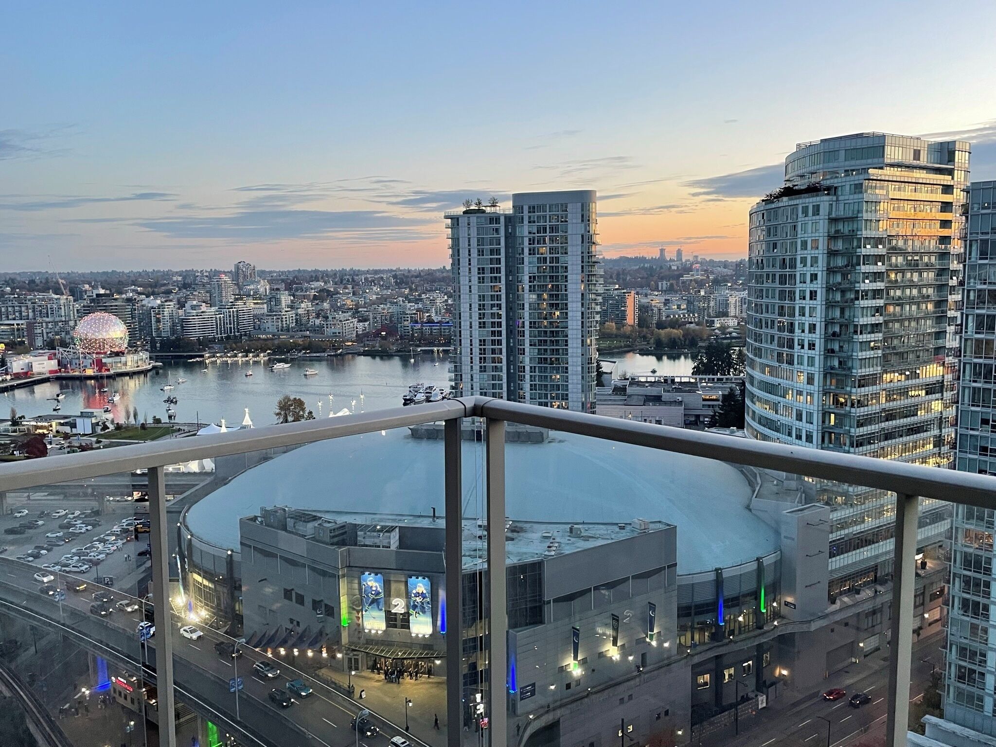 A high-rise building with a view of a cityscape, including a stadium and a river.