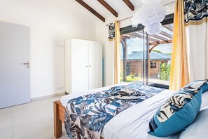 Ein Schlafzimmer mit Bett, weißem Kleiderschrank und Blick ins Freie.