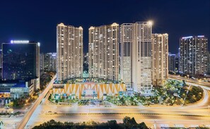 A high-rise building complex with multiple floors, surrounded by well-lit streets and other buildings. -  Vinhomes D'Capitale Luxury Apartment - Brian Homes (Cau Giay)