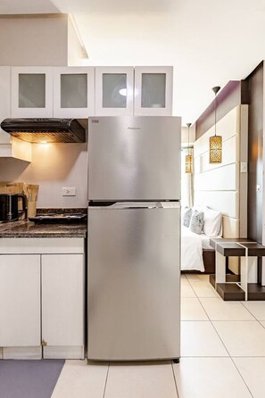 Eine moderne Küche mit einem Edelstahlkühlschrank, weißen Schränken und einem eingebauten Backofen.