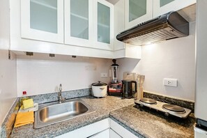 Eine Küche mit Spüle aus Edelstahl, Mixer, Wasserkocher und Toaster.