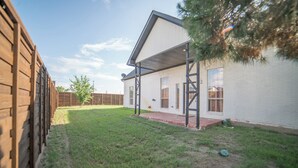 A single-story house with a covered porch, a brick pathway leading to the front door, and a fenced backyard. - A Quiet Lakefront Retreat for Relaxed Getaways (Oak Point)