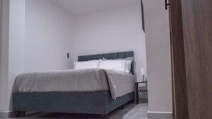 Une chambre à coucher avec un lit, une table de chevet et une porte.