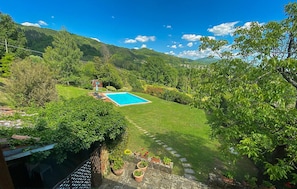 A backyard with a swimming pool, surrounded by lush greenery and hills. - Gorgeous home in Villa Collemandina (Villa Collemandina)