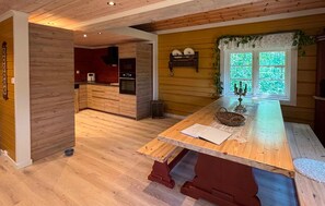 A kitchen with wooden cabinets, a central island, and a window with greenery outside. - Lovely home in Prestestranda with sauna (Prestestranda)