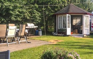 A gazebo with a tiled roof, a barbecue grill, and outdoor seating. - Stunning home in Sandefjord with WiFi (Sandefjord)