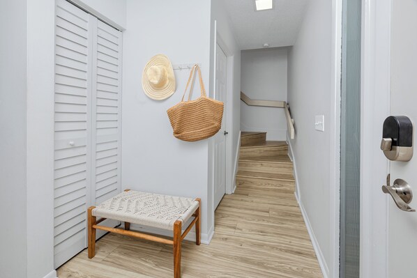 A hallway with a bench, a hat, and a basket on the wall. - Townhouse on the Beach (Indian Shores)