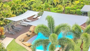A pool area with lounge chairs and a shaded seating area.