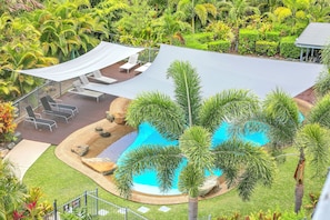 Ein Poolbereich mit Liegestühlen und einer schattigen Lounge.