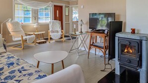 A cozy living room with a fireplace, comfortable seating, and a television. - Beach front home in Bullaren with house sea view (Bullaren)