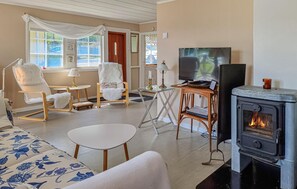 Ein gemütliches Wohnzimmer mit Kamin, bequemen Sitzmöglichkeiten und einem Fernseher.