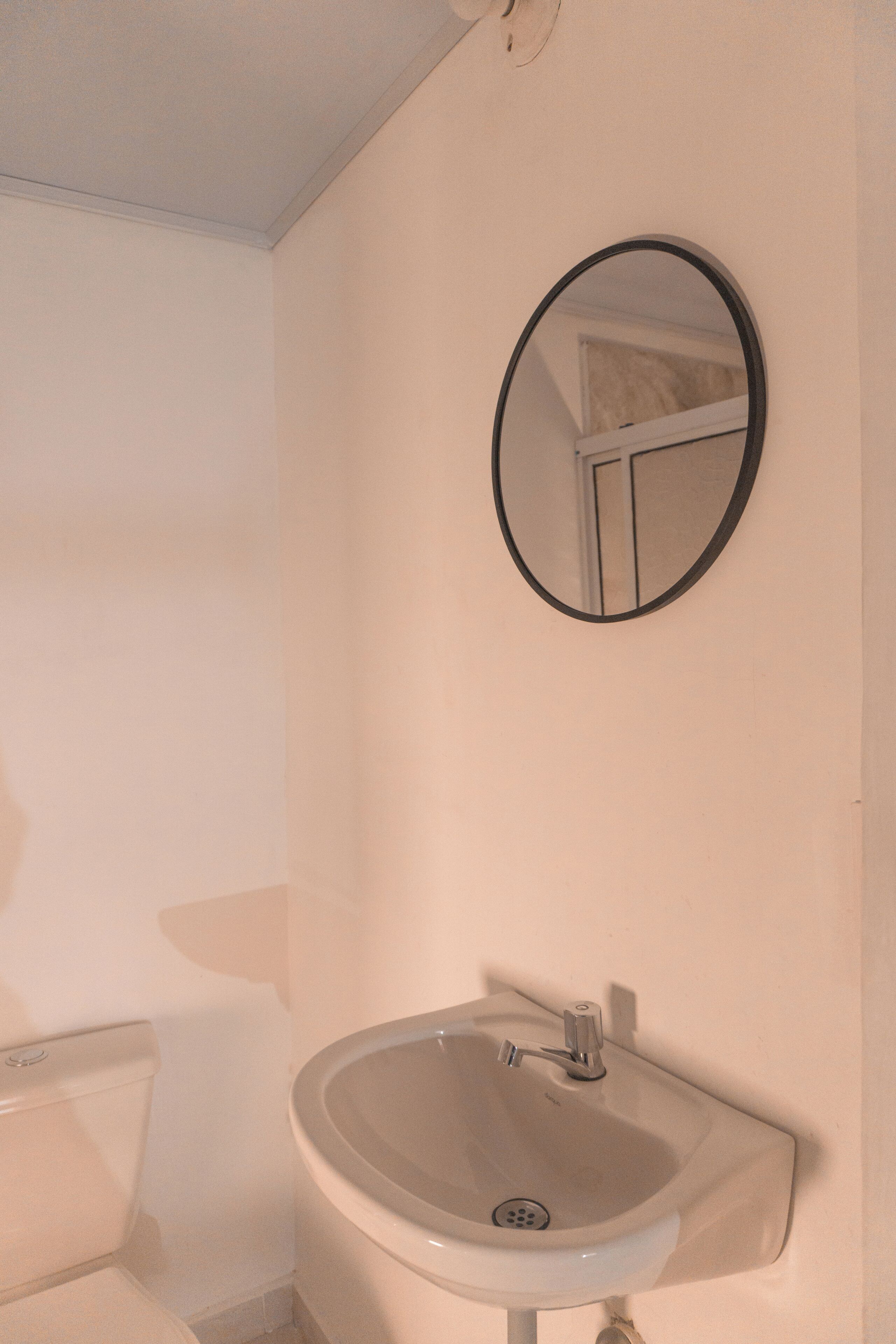 A bathroom with a sink, mirror, and toilet.