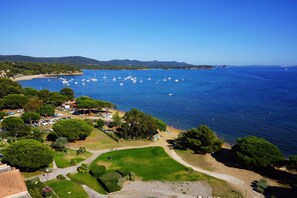 Una zona costiera con barche, una spiaggia e un campo da golf.