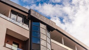 A modern building with a sign that reads 'Relax Inn.' - Relax Inn Hotel (Durrës)