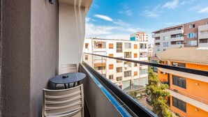 A balcony with a table and chairs, overlooking a cityscape with multi-story buildings. - Relax Inn Hotel (Durrës)