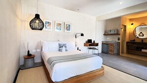 Ein modernes Schlafzimmer mit einem hölzernen Bett, einem Nachttisch, einer Lampe und einem kleinen Schreibtisch mit Stuhl.