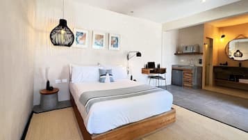 Un dormitorio moderno con una cama de madera, una mesita de noche, una lámpara y un pequeño escritorio con una silla.