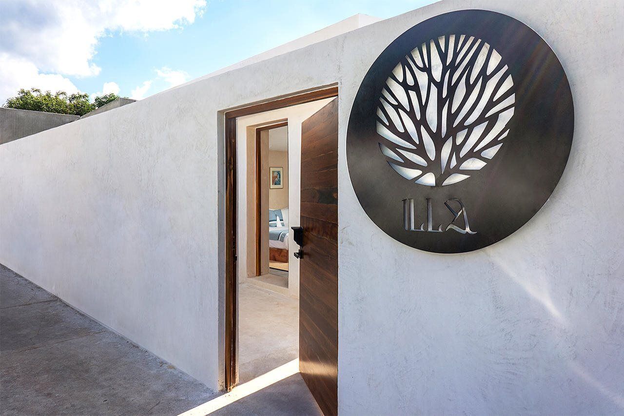 A modern building entrance with a circular sign featuring a tree design and the number '112'.
