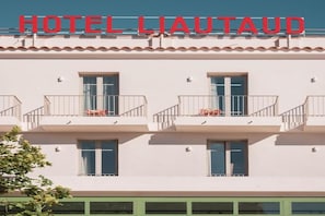 A hotel with a sign reading 'HOTEL LIAUTAUD' above the entrance. The building has multiple balconies with railings and windows. - Hotel Liautaud (Cassis)