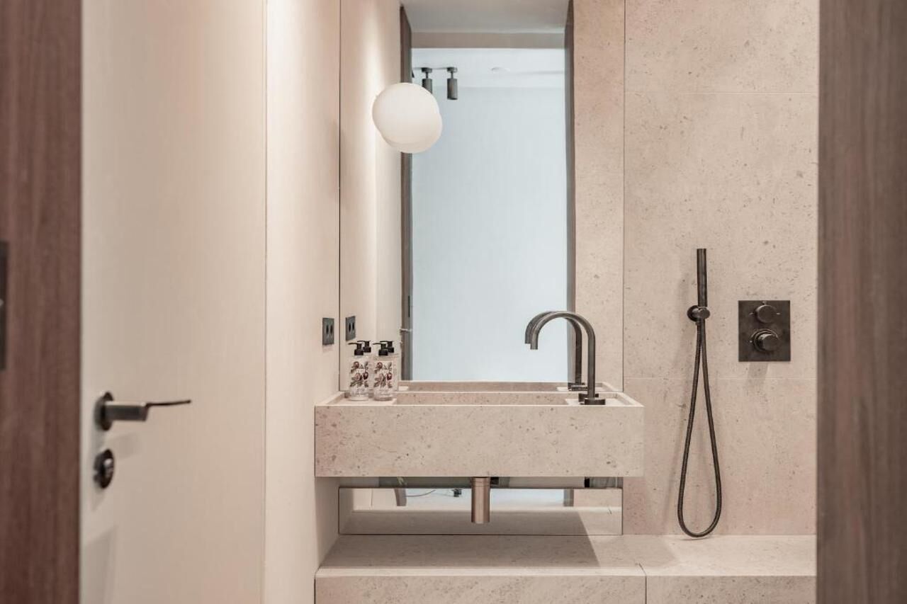 Une salle de bain moderne avec un lavabo, un miroir et une douche.
