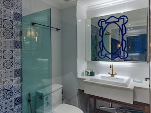 A bathroom with a glass shower enclosure, a white sink, and a mirror with a blue frame. - Seven Seas Cote D'Azur Nice by GV (Tambon Na Chom Thian)