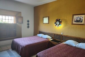 A room with two beds, a window, a wall clock, and a framed picture. - Hotel Mision Santa Ma Catavina (Catavina)