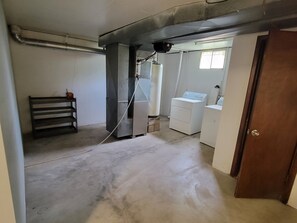A laundry room with a washing machine, dryer, and a bench. - Marvelous 3-room townhome in Raytown. 5-8 min from stadiums, World Cup! (Raytown)