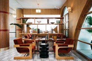 A modern interior with wooden furniture, a central table, and a large window.
