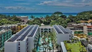 A resort with a pool, solar panels, and a view of the ocean. - Sugar Marina Hotel Pop, Kata Beach (Karon)
