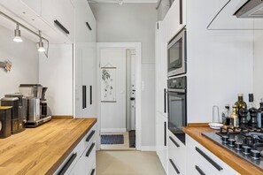 Eine moderne Küche mit Holzarbeitsplatte, integrierten Geräten und Blick in den Essbereich.