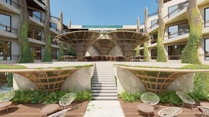 A hotel with a central atrium, outdoor seating, and greenery. - Ana y Jose Hotel Beach Club Holbox (Isla Holbox)
