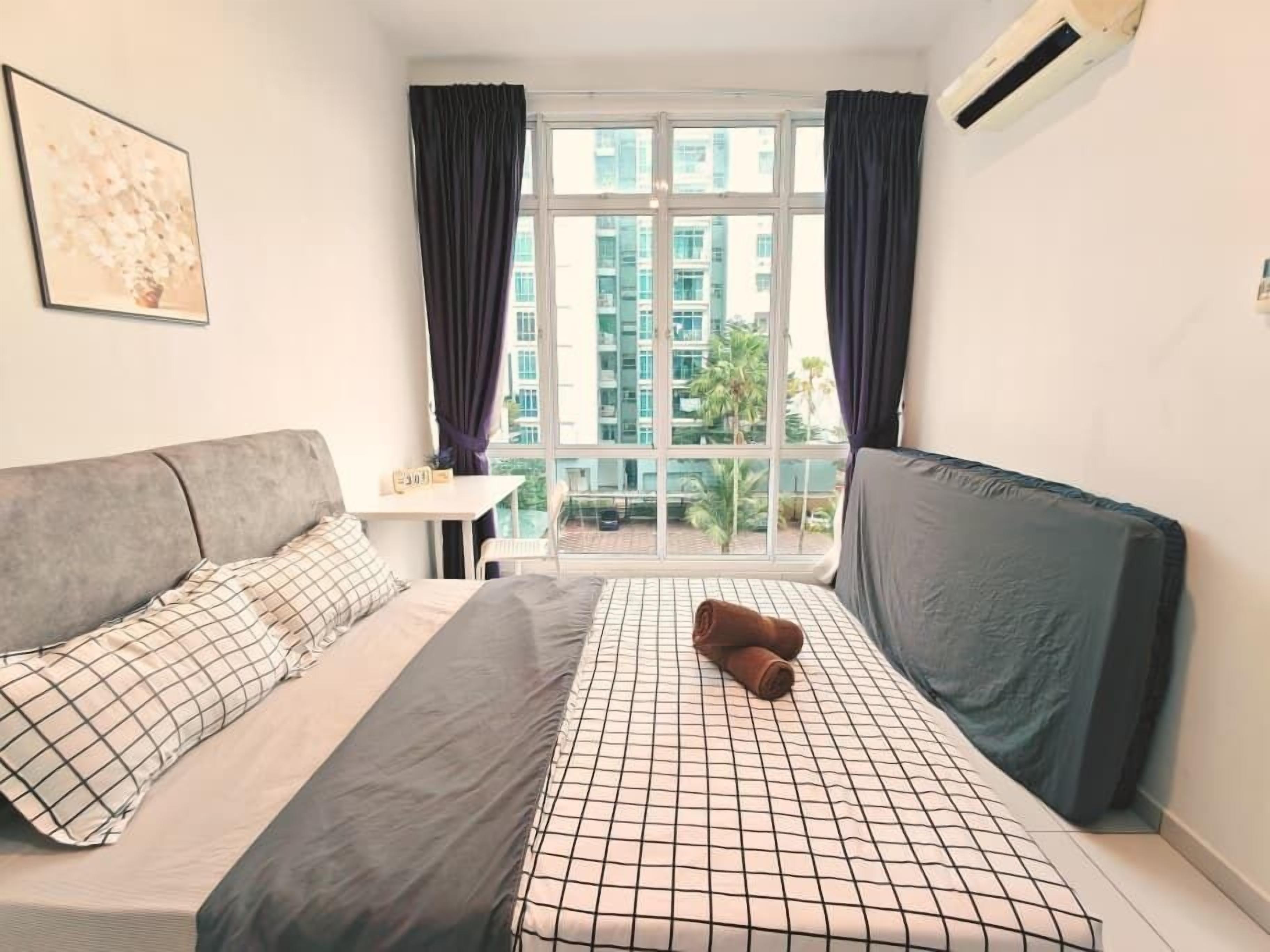 Une chambre à coucher comprenant un lit, un canapé, une fenêtre avec des rideaux et un appareil de climatisation.
