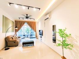 A modern living room with a sofa, a coffee table, a floor lamp, a ceiling fan, and a large window with curtains.