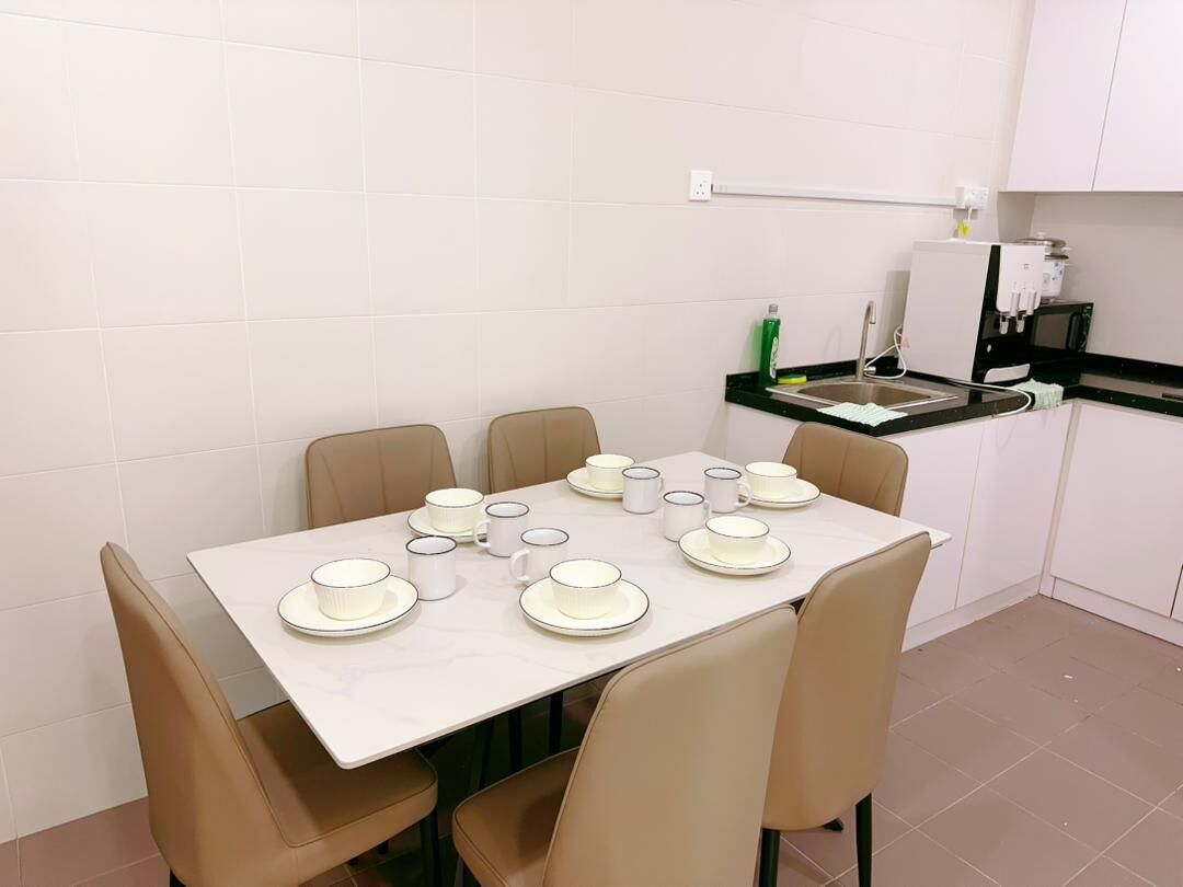 A dining area with a table set for six, equipped with plates, bowls, and cups.