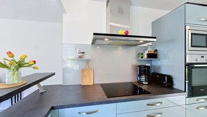 Una cocina moderna con estufa integrada, cafetera y tostadora.