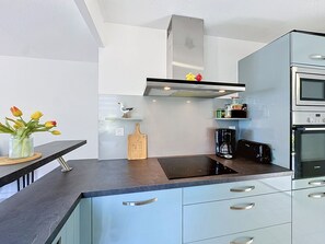 Eine moderne Küche mit Einbauherd, Kaffeemaschine und Toaster.