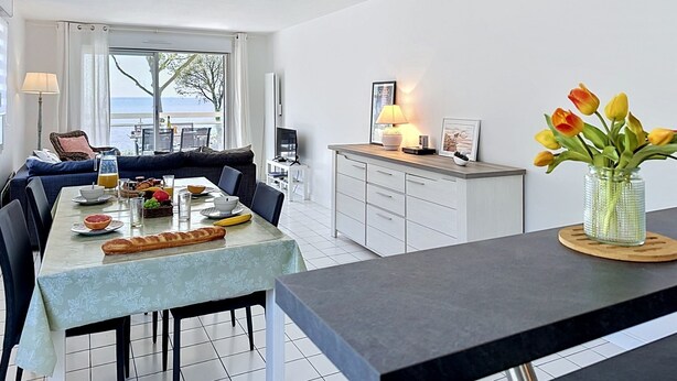 Una cocina moderna con comedor, sofá y vista al mar.