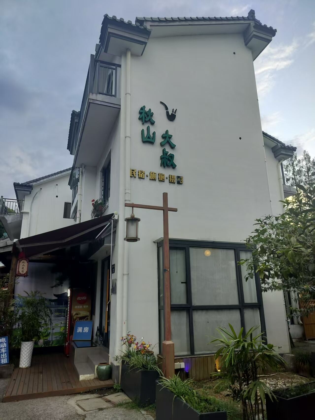 Un bâtiment sur lequel on peut lire l'inscription « 秋山大叔 » et « maison d'hôtes · hôtel · salon de thé ».