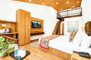 Una habitación de hotel moderna con cama, televisión, escalera y techo de madera.