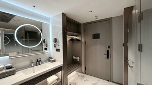 Un baño moderno con tocador, un espejo grande, barra para toallas y cabina de ducha.