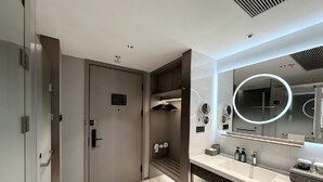 A modern bathroom with a marble floor, a large mirror with a circular light, and a built-in shower area. - PALACE Hotel（Hangzhou Huayin Tower Hangzhou City University） (Hangzhou)