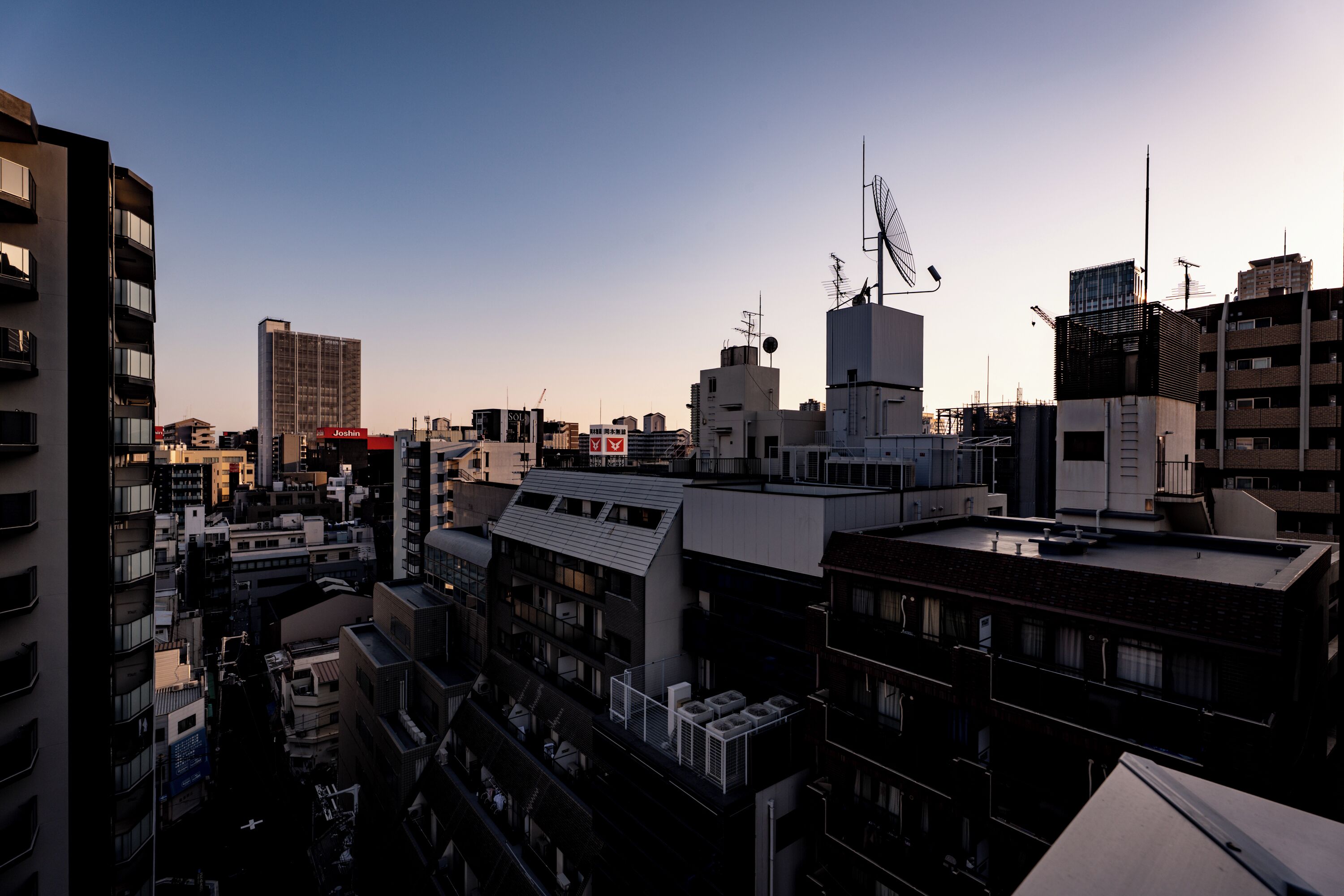Un horizonte urbano denso con rascacielos, algunos con señalización visible, y un cielo despejado.