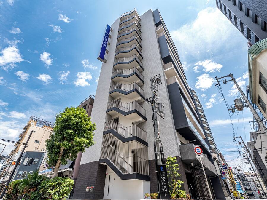 A multi-story hotel with a modern architectural design, featuring balconies and a prominent entrance.