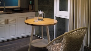 Una cocina moderna con una mesa redonda de madera, una silla de mimbre y una lámpara colgante.